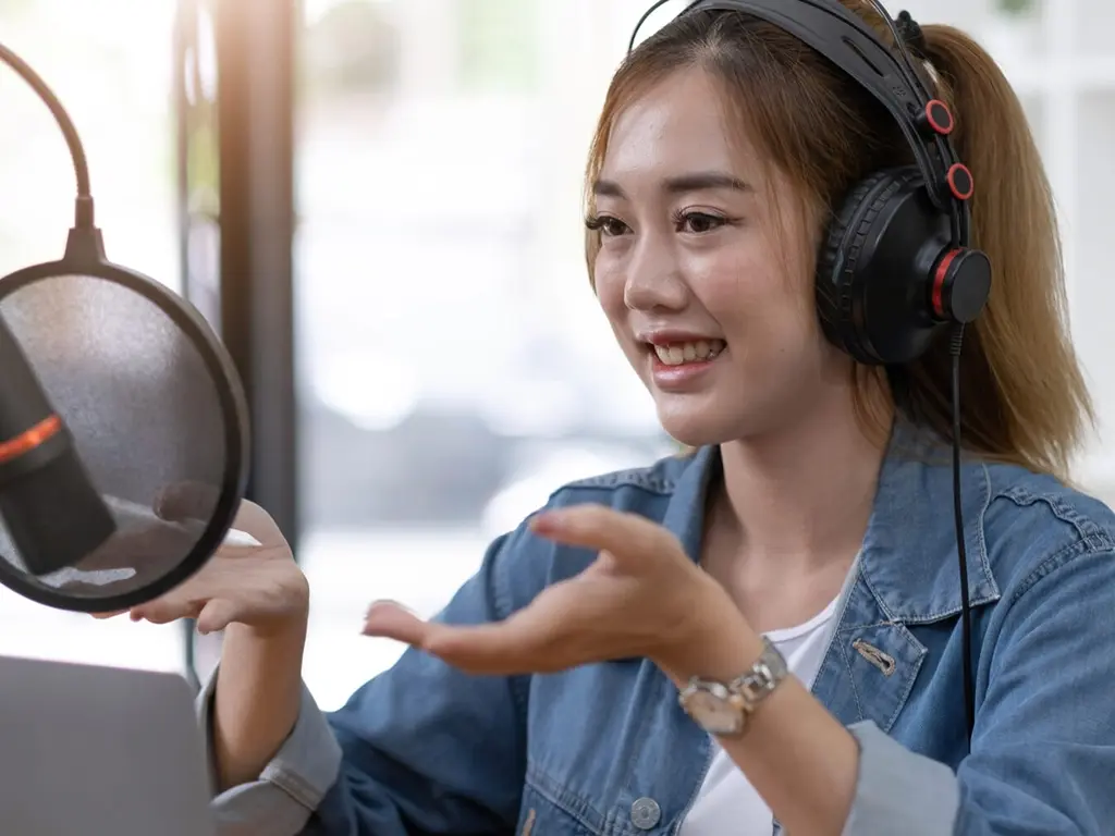 Middle school student speaking in front of a student microphone gesturing with her hands