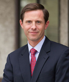 Michael F. Fleming in a suit and red patterned tie