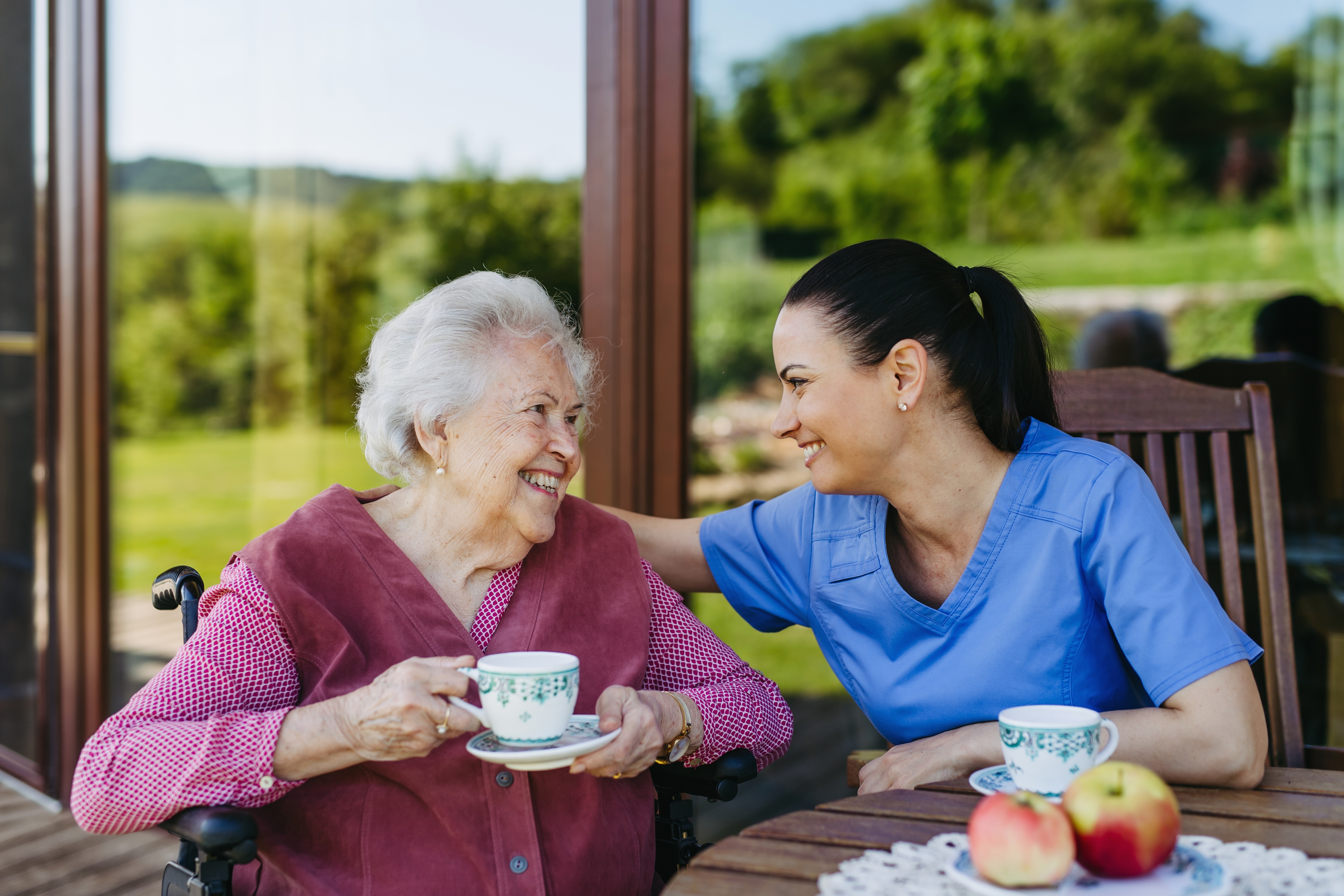 Nurse sharing tea with an older woman