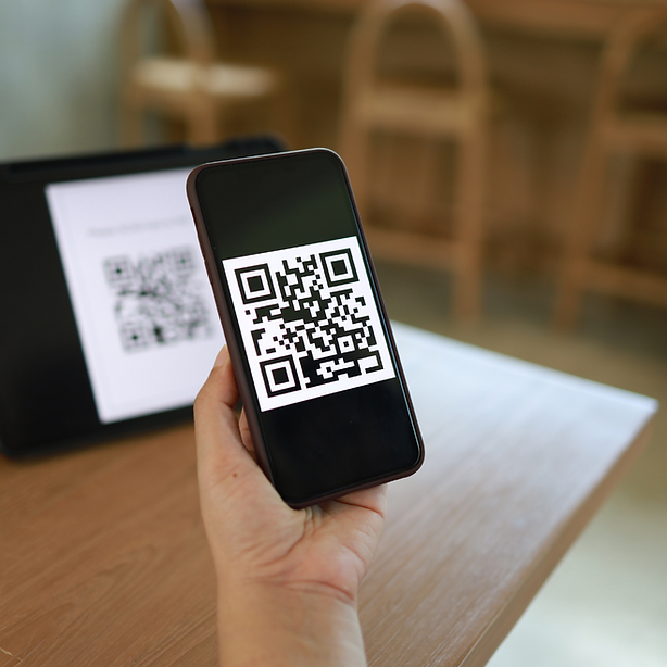 Phone in hand scanning a QR Code from a tablet