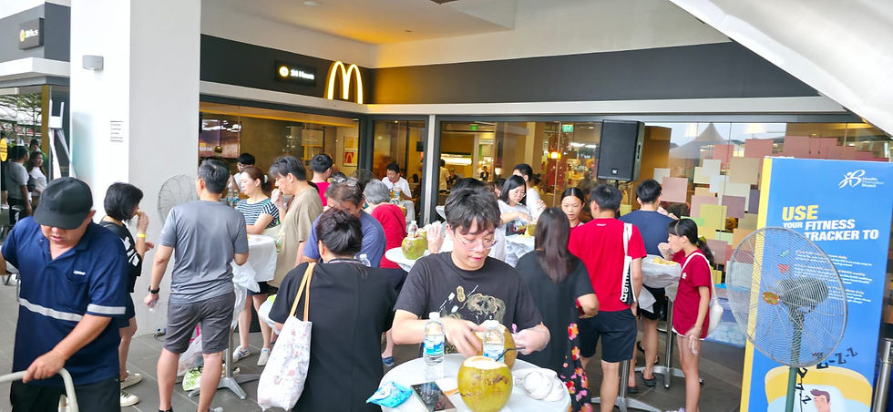Emcee Singapore - A lively crowd gathers outside McDonald's, enjoying refreshing drinks amidst our Sun Plaza Durian Buffet festive atmosphere.