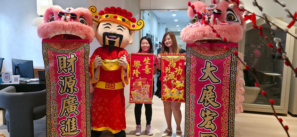 Emcee - Festive Chinese New Year celebration featuring a God of Wealth character and a traditional lion dance, bringing prosperity and good fortune with vibrant scrolls and decorations during SPTel event.