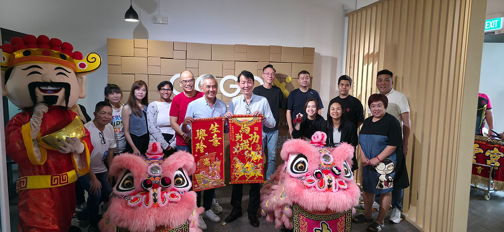 Emcee - The team from GOGOX gathers for a festive celebration featuring a traditional Chinese lion dance. Our customers hold decorative red banners with Chinese characters, and a cheerful figure in a God of Wealth costume stands to the side, adding to the vibrant atmosphere.
