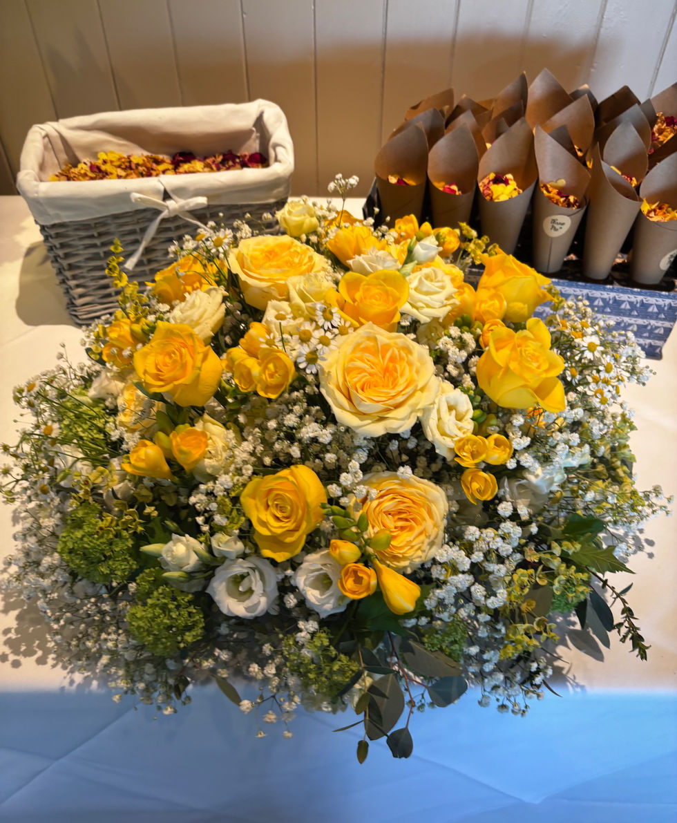 Yellow and white flower arrangement on a table.