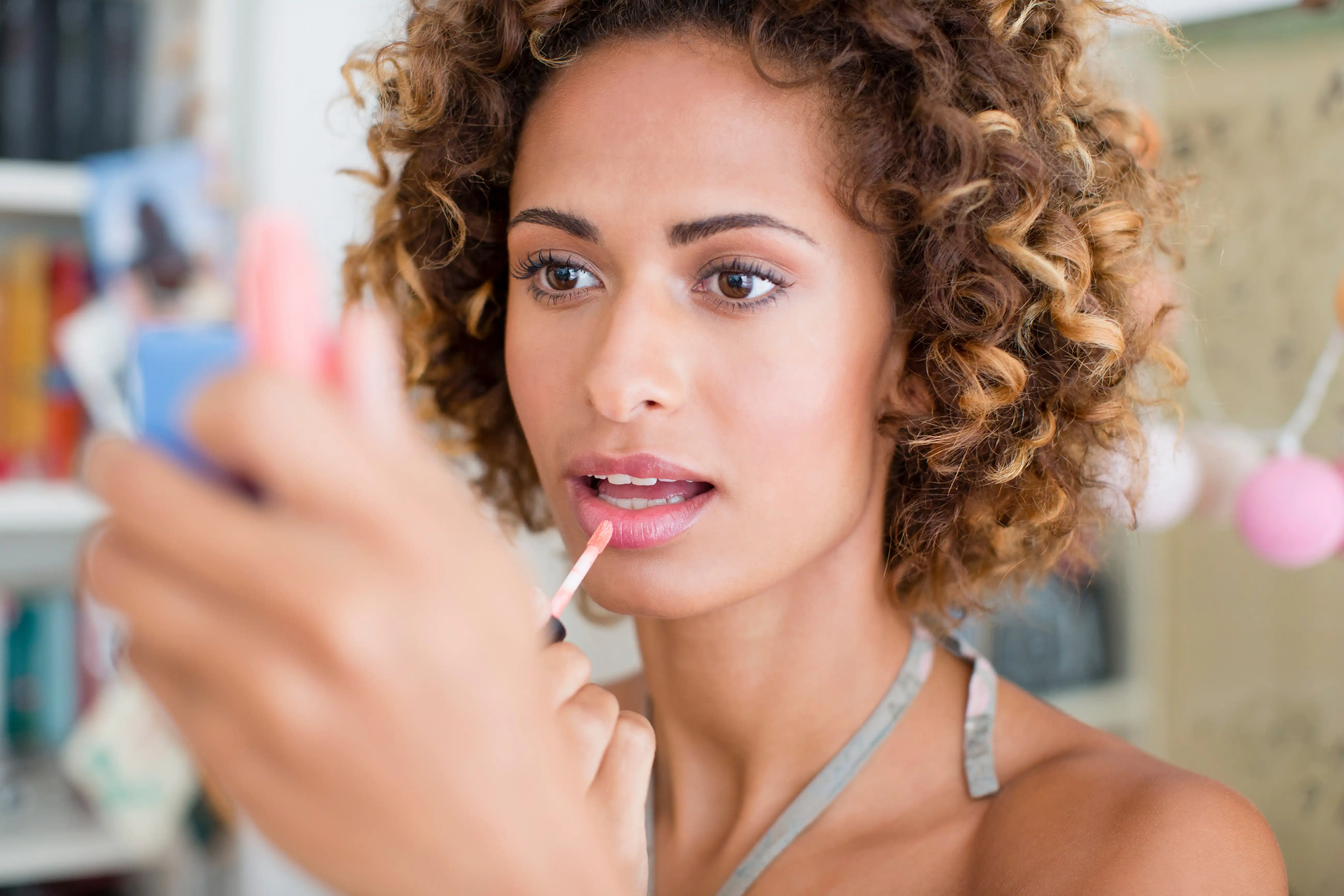 woman-applying-make-up infront of a mirror