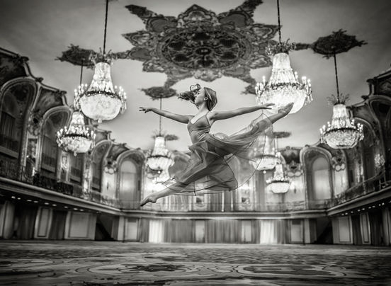 A ballerina performing a beautiful leap in an elegant ballroom, capturing the grace and strength of her movement in a refined, majestic setting.