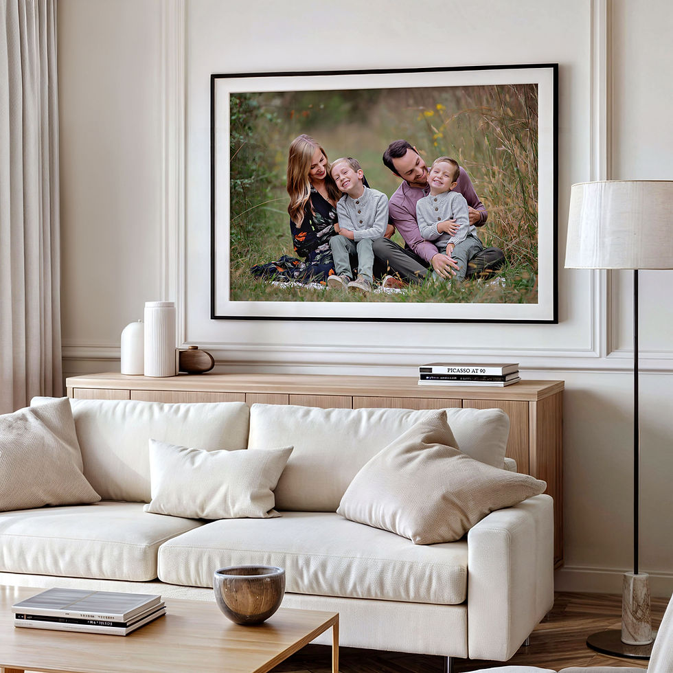 Living room with a large framed photo above a beige sofa. Photo shows a happy family sitting on grass.
