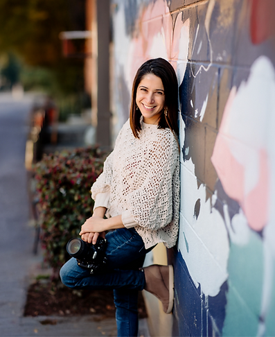Woman photographer in Atlanta leaning against mural wall mural Senior Dance
