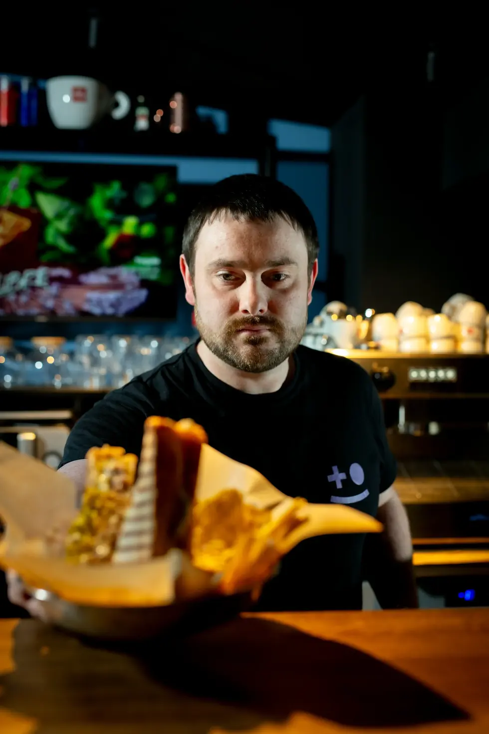 Portrait en situation d’un restaurateur présentant un plat, réalisé par un photographe professionnel à Viarmes