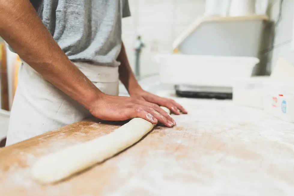 Gestes du boulanger façonnant une baguette – photographie de savoir-faire artisanal par un photographe culinaire