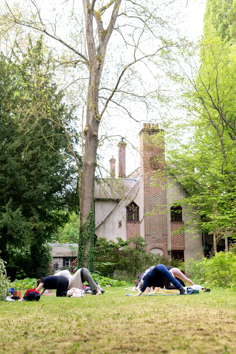 Cours de yoga en extérieur devant une maison ancienne – photographe professionnel et ambiance naturelle.