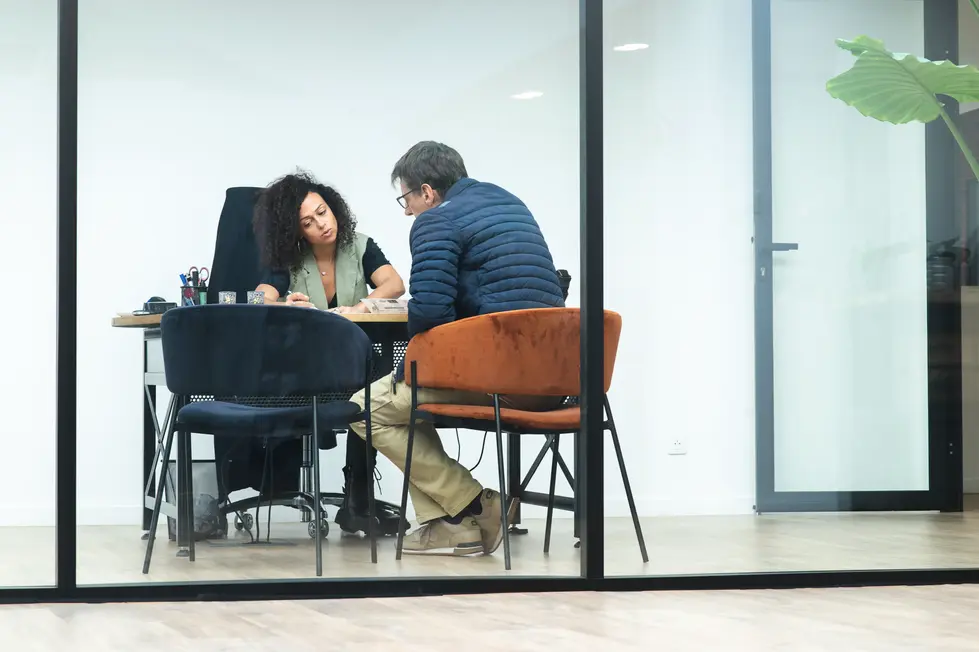 Conseillère échangeant avec un client à son bureau : Photographe professionnel relation client | entretien personnalisé dans le showroom Technal