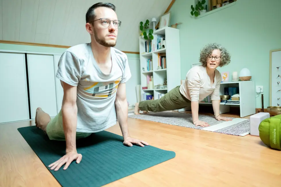 Professeure de yoga souriante avec un élève – reportage bien-être par photographe professionnel.