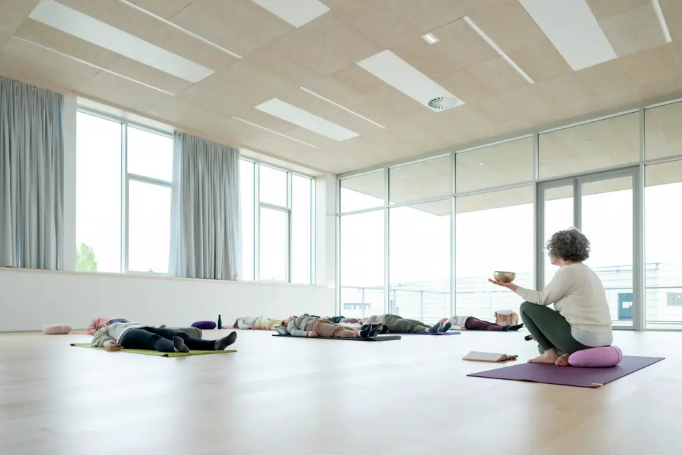 Professeure de yoga guidant des élèves dans une salle lumineuse – photo bien-être par un photographe professionnel.
