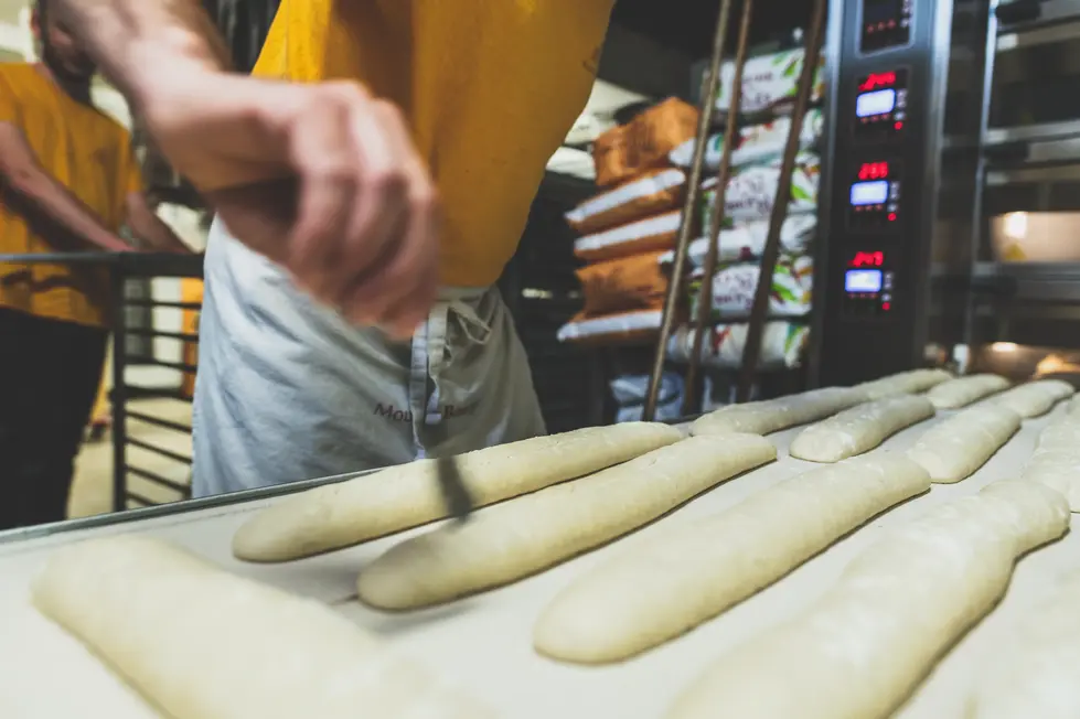 Préparation manuelle des baguettes sur toile en boulangerie artisanale – photo de reportage métier entreprise