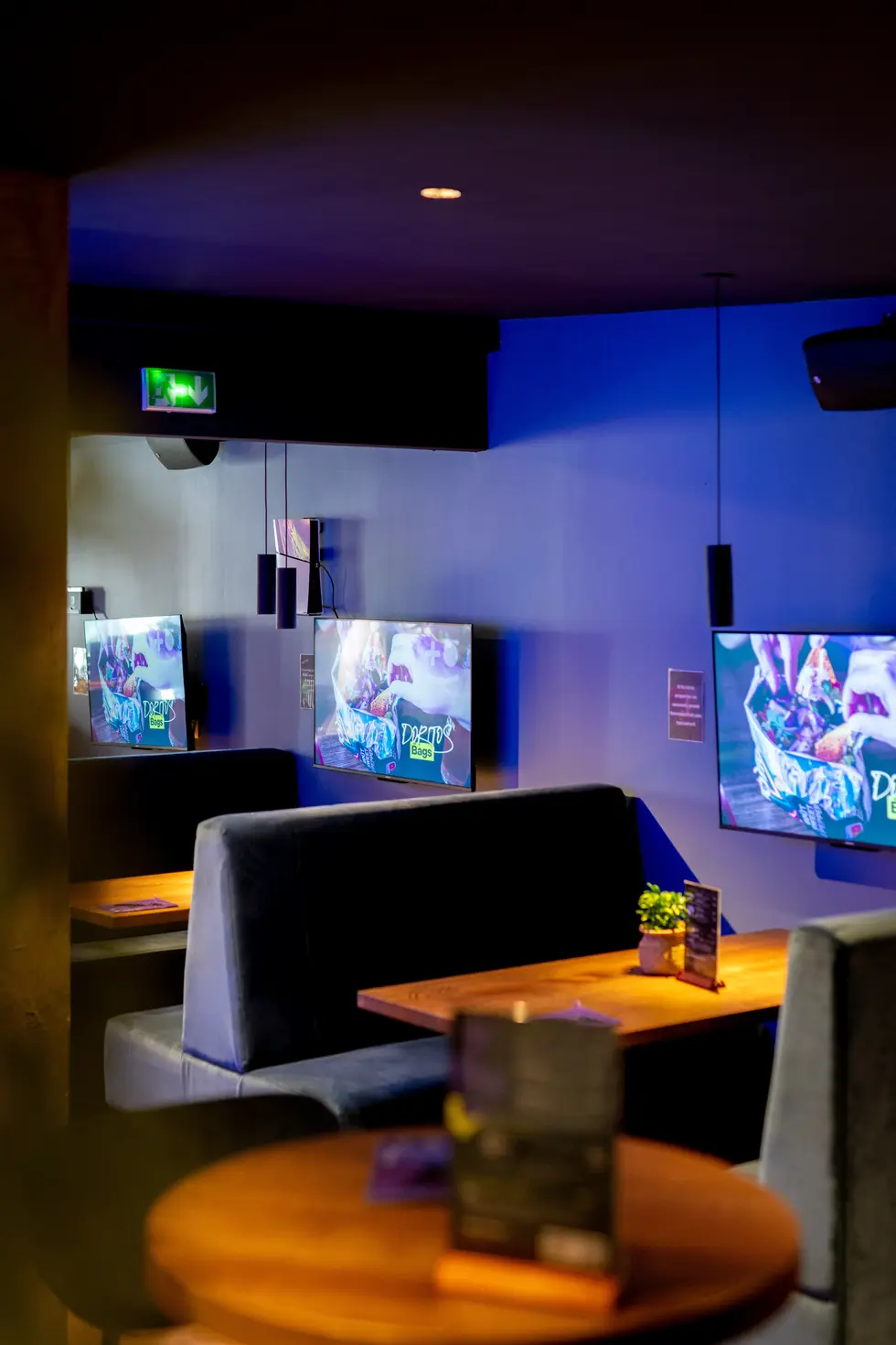 Espace lounge du Kappa Bar à Viarmes avec banquettes et écrans muraux – photo d’ambiance prise par un photographe professionn