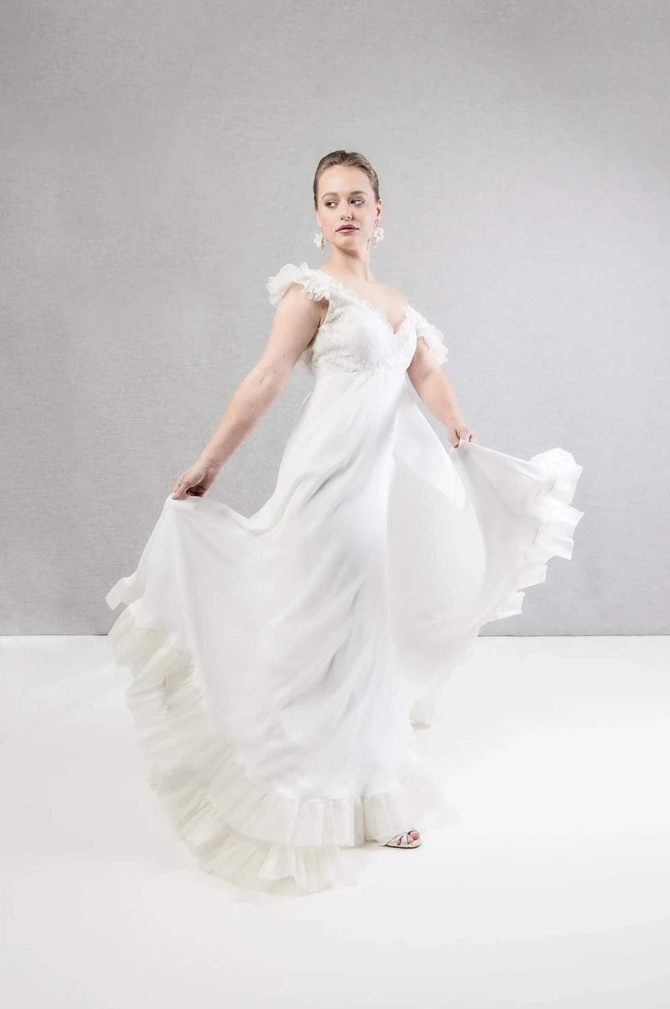 Mariée en robe fluide virevoltante, pose dynamique – photo de collection mariage captée par Fred Photo en studio.
