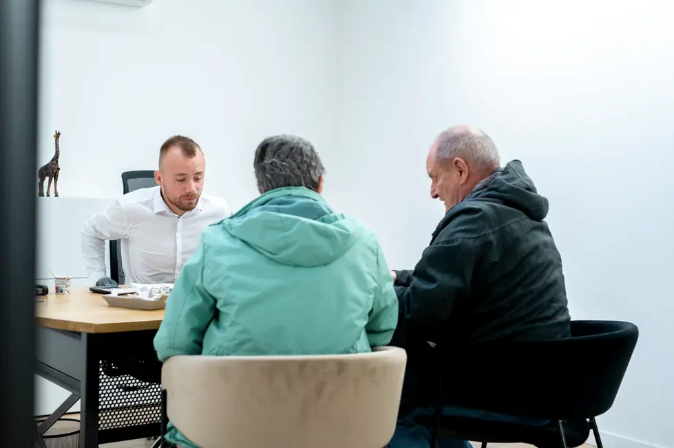Échange entre clients et conseiller dans un bureau vitré : Photographe professionnel entreprise | moment de conseil dans un espace confidentiel