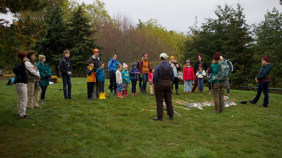 A group of people gathered together attentively listening DNDA give a run down of their event,