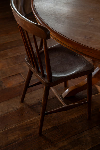 Antique wooden chair at dining table in The Woolshed at St Leonards Vineyard Cottages boutique accommodation in Marlborough, New Zealand