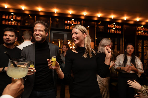 Vrolijke man en vrouw proosten met borrelglaasjes gevuld met limoncello en limoncello spritz