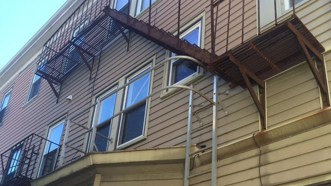 Rusted fire escape platform showing steel corrosion