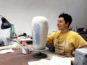 Daniela Moretti in her studio working on Italian handmade ceramics, shaping a large sculptural vessel with Kurinuki-inspired carving.