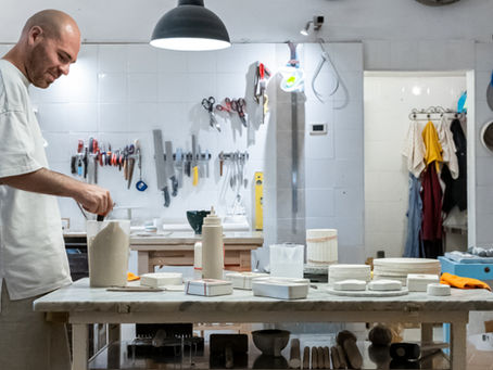 Claudio Campana working in his ceramic studio in Italy, surrounded by moulds, tools, and works in progress.