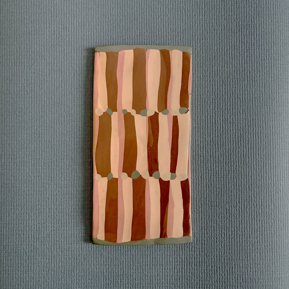 Nerikomi ceramic wall work by Anna Resmini with layered striped pattern in pink, brown and grey tones