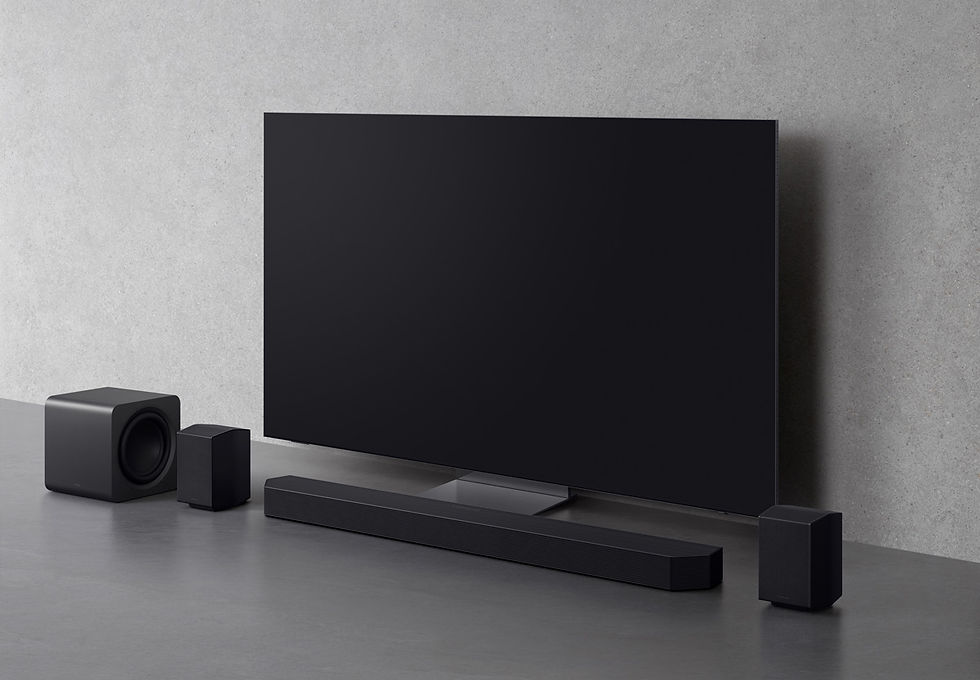 Televisor negro apagado con barra de sonido y altavoces sobre una mesa gris, en un entorno minimalista marca samsung