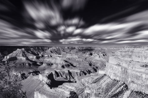 A long-exposure, black-and-white photograph of clouds over the Grand Canyon.