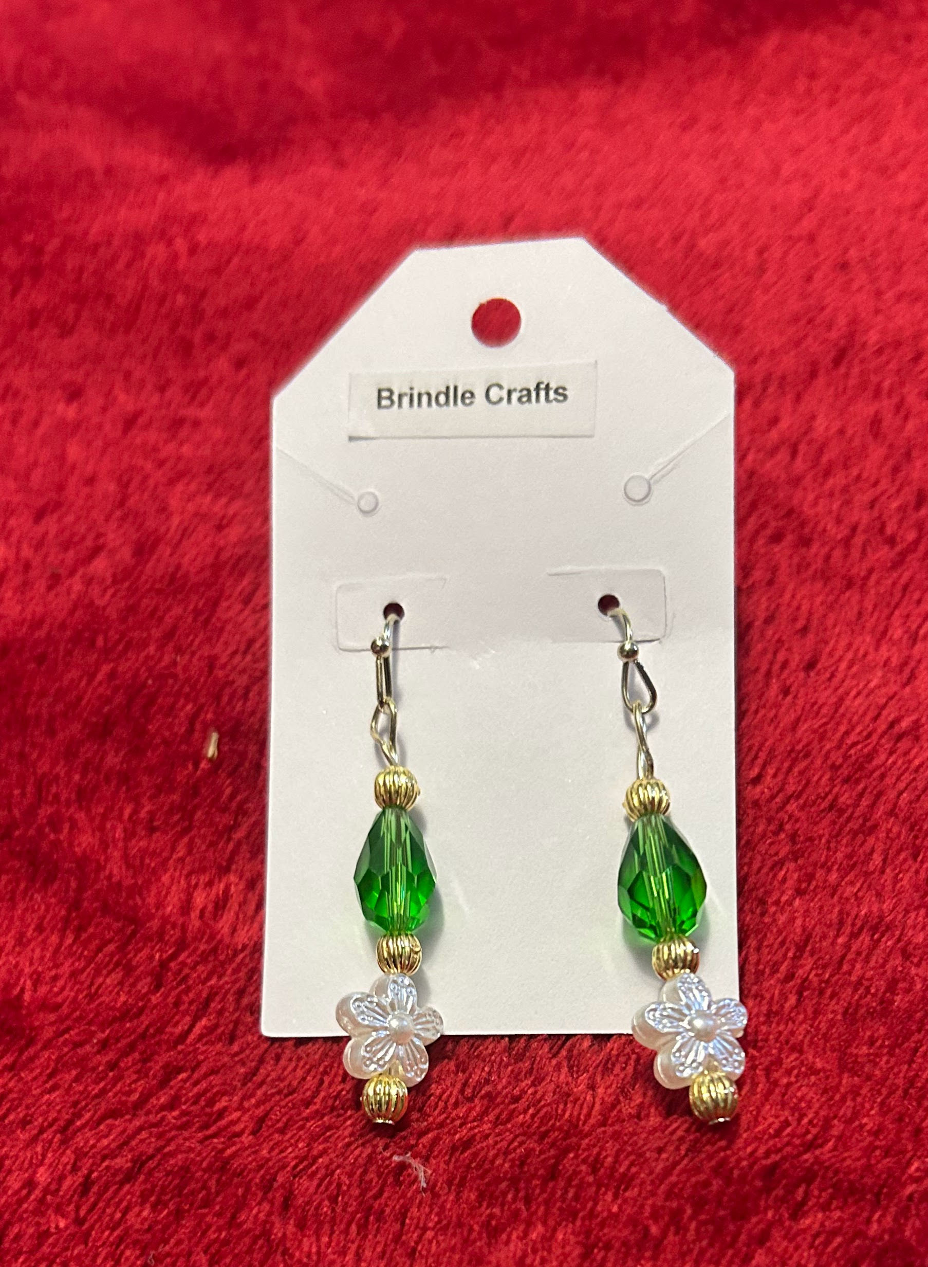 Green dangle earrings with pearl colored flowers accented by gold beads