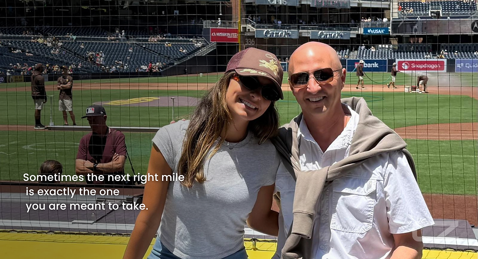 A smiling woman in a cap and man in sunglasses at a baseball stadium. Text: "Sometimes the next right mile is exactly the one you are meant to take."