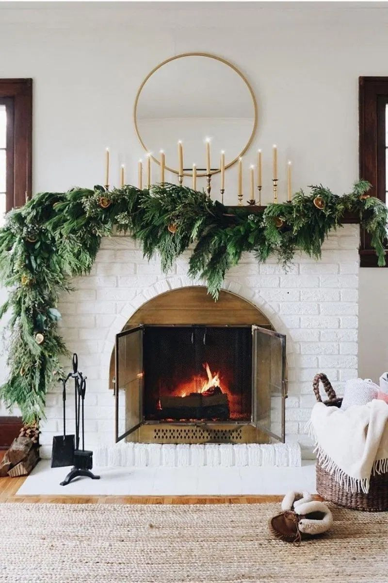 A luscious wreath draped over a simple fireplace mantle.