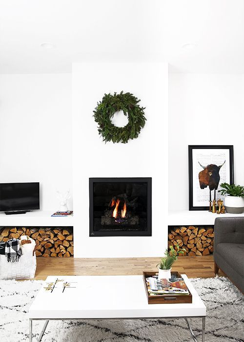 Green Christmas wreath over a modern fireplace.
