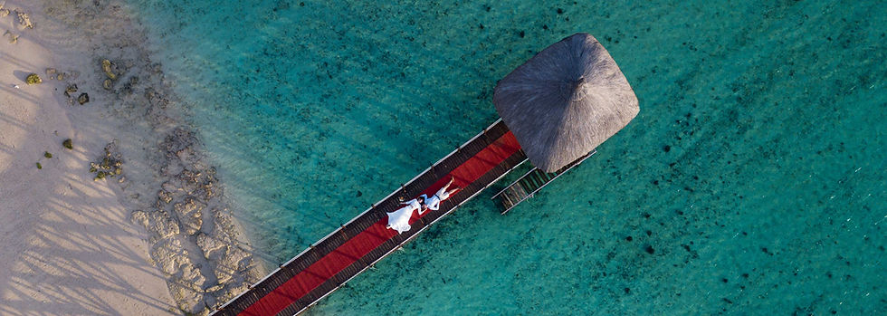 Aerial view of loving couple lying on a jetty on their wedding day on the island of Mauritius