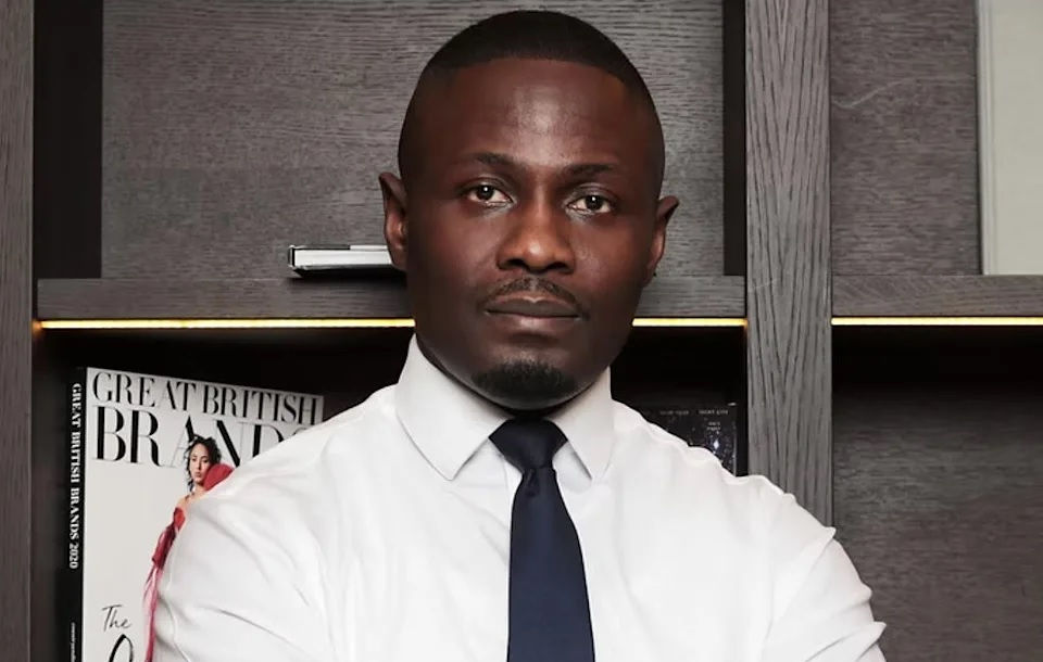 Tevin Tobun is dressed in shirt and tie with his arms crossed looking at the camera