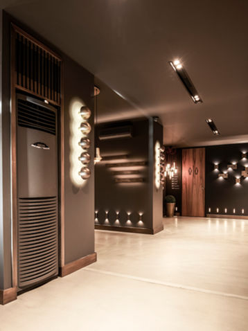 Dr-Light showroom ürün sergileme koridoru koyu ton mekan arka aydınlatmalı raf sistemi derinlemesine perspektif - DPI Group iç mimari