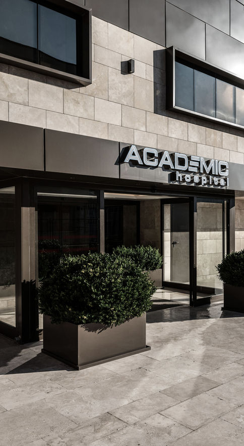 Academic Hospital ana giriş kapısı yakın çekim gündüz ACADEMIC hospital tabela cam giriş kapısı siyah topiary bitkiler - DPI Group mimari tasarım