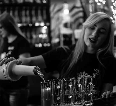 Kavatender Bartender pours shots of exotic kraom tea into shot glasses at Dharma Hookah Kava Lounge