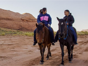 Two girls riding horses