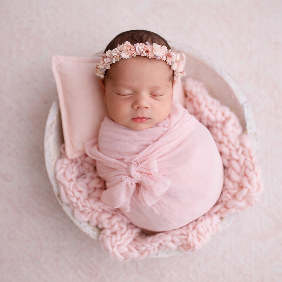 Newborn baby girl in pink swaddle with floral crown in bowl, Manchester newborn photographer Monika Szmidt