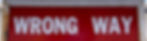 red wrong way sign with text wrong way painted in white