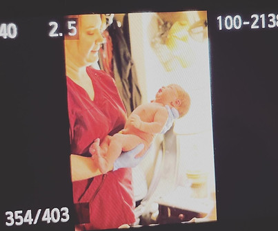Midwife Kaleigh holds just born infant at home birth