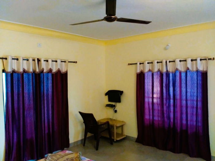 Devbag Malvan room with purple curtains