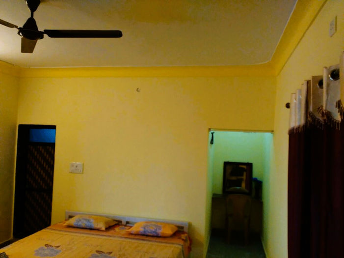Yellow room with bed and ceiling fan