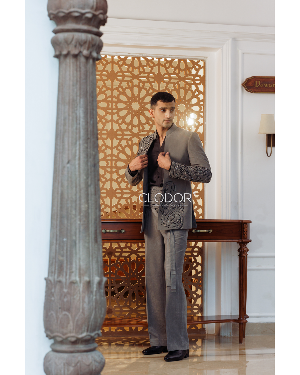 Grey suede embroidered shrug with pleated flared trousers and belt-style waist — bespoke by Clodor.