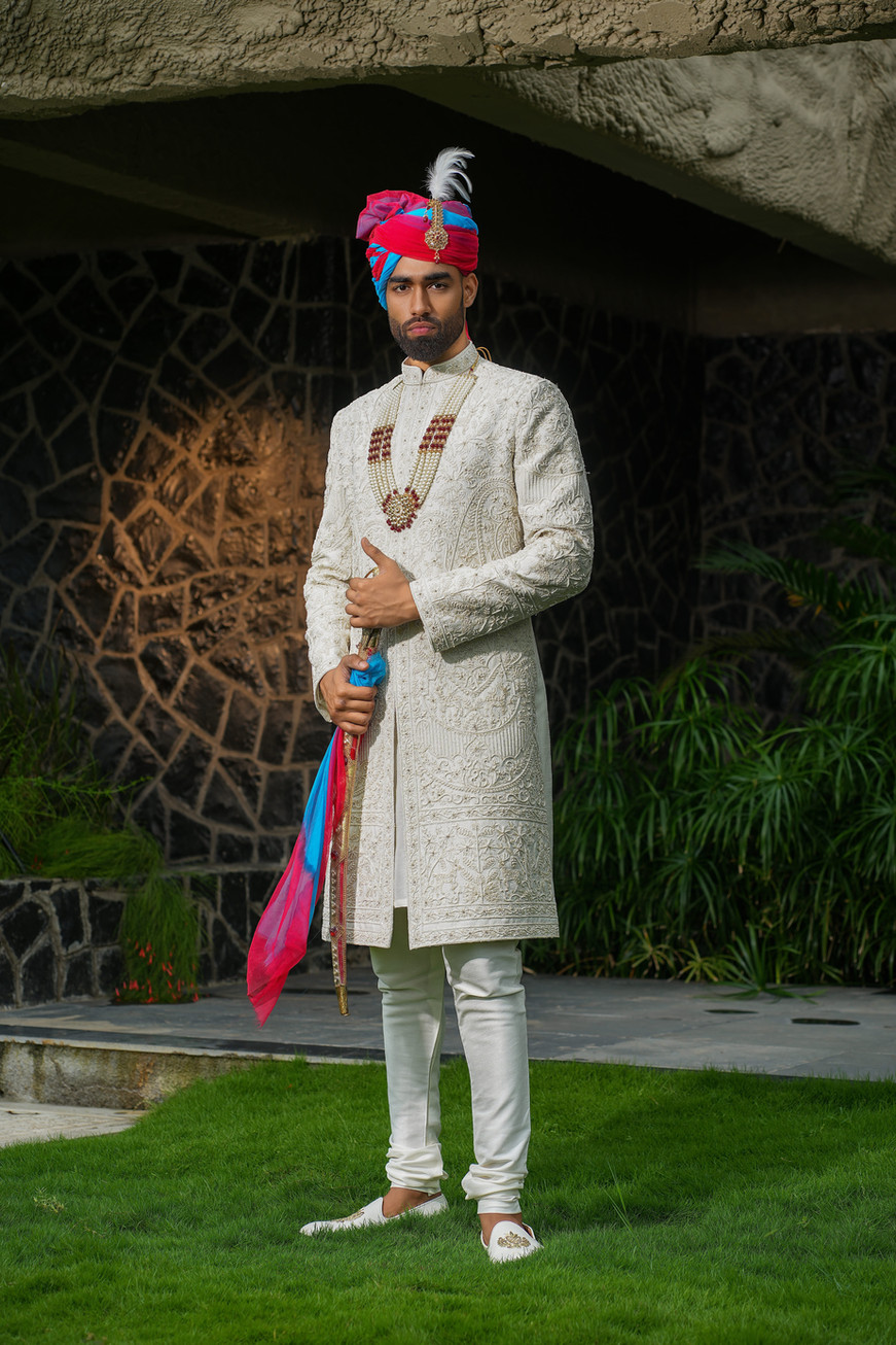 Full length cream sherwani for groom with same-tone kurta choodidaar and embroidered dupatta – bespoke wedding wear by Clodor