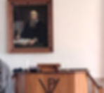 Ein großes Porträt von Menno Simons hinter der Kanzel