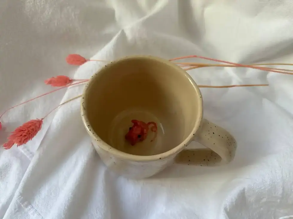 Ręcznie wykonany ceramiczny kubek z figurką lisa na spodzie.